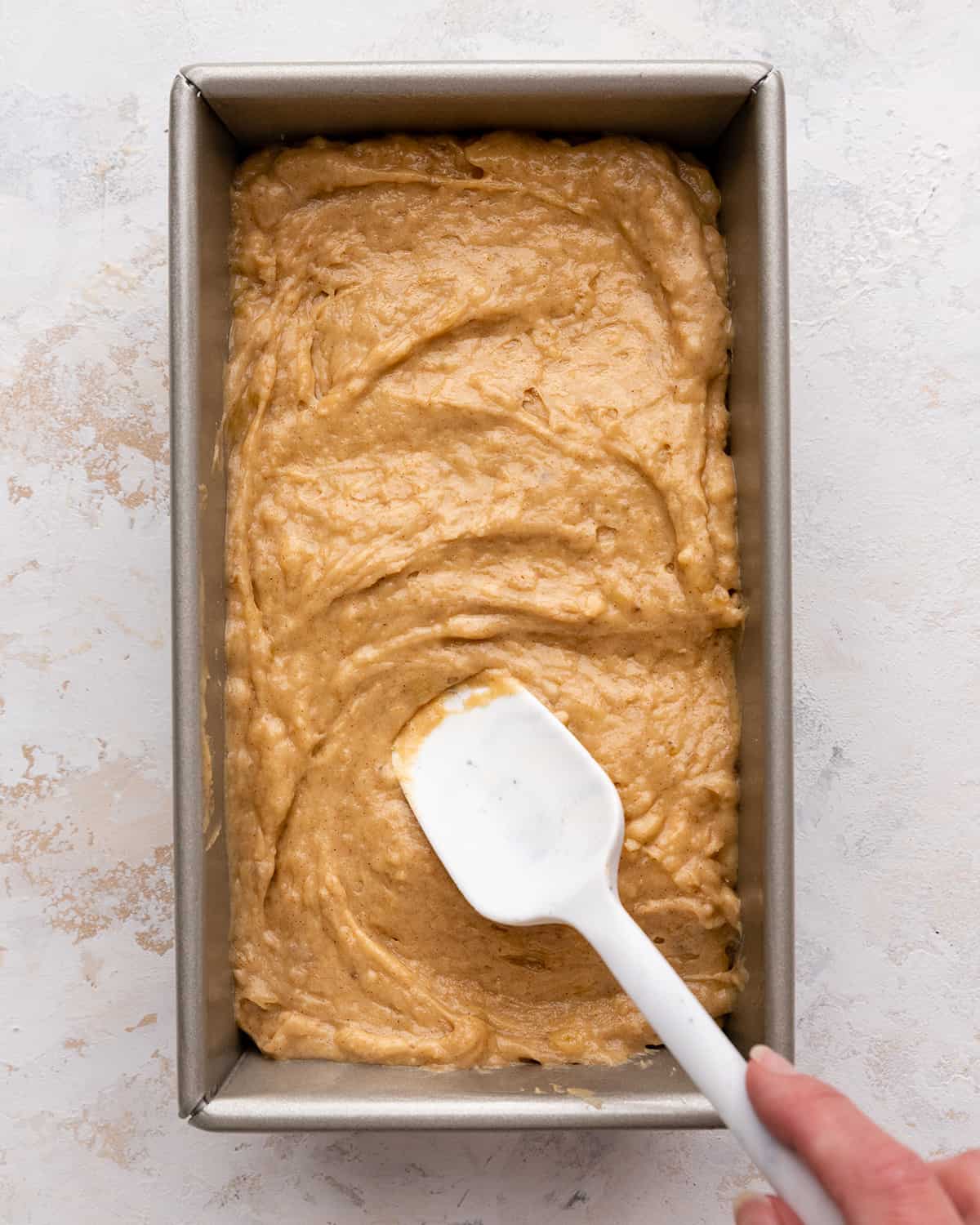 Peanut Butter Banana Bread batter being spread into a baking pan