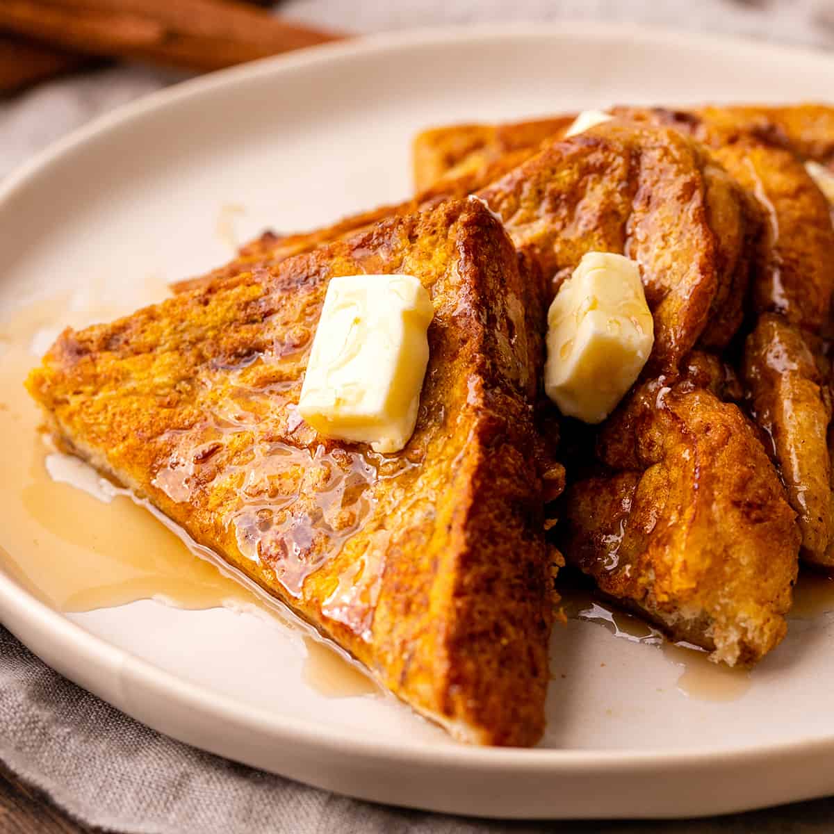 4 slices of Pumpkin French Toast on a plate with butter and syrup 