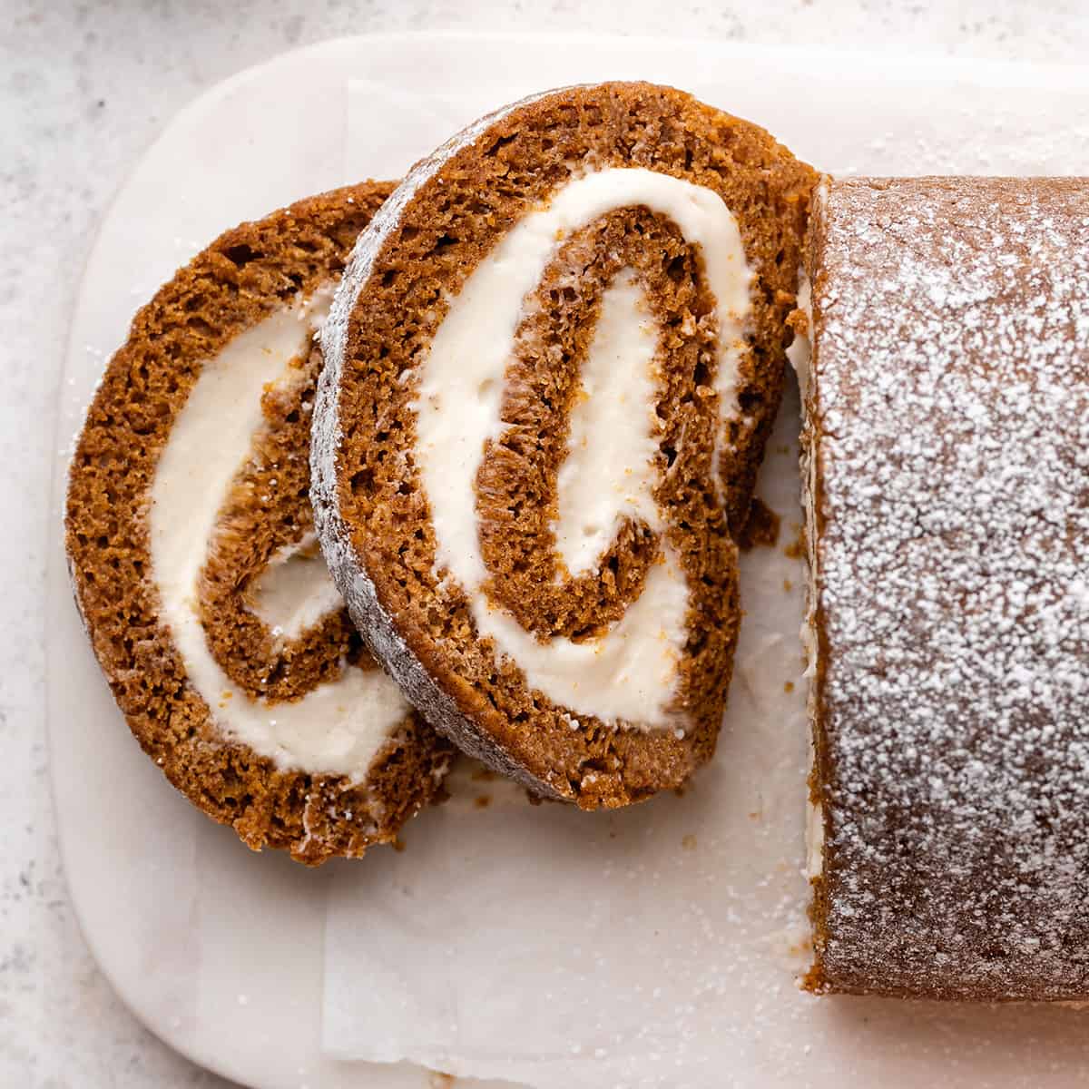 two slices of Pumpkin Roll Cake on a serving plate