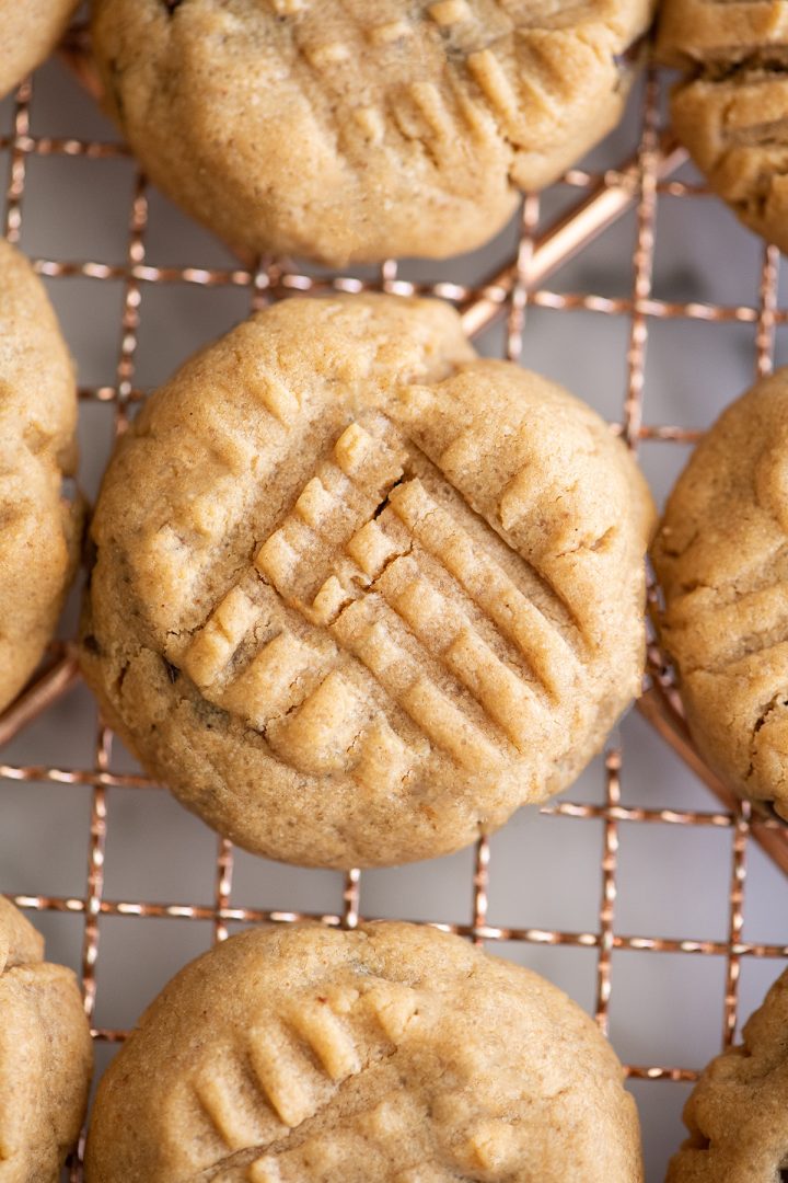 overhead photo of 3 peanut butter cookies on a wire cooling rack 