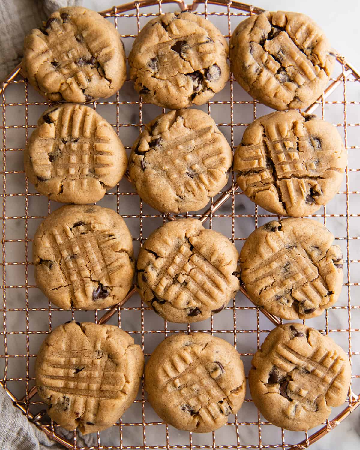 12 Peanut Butter Chocolate Chip Cookies on a wire cooling rack