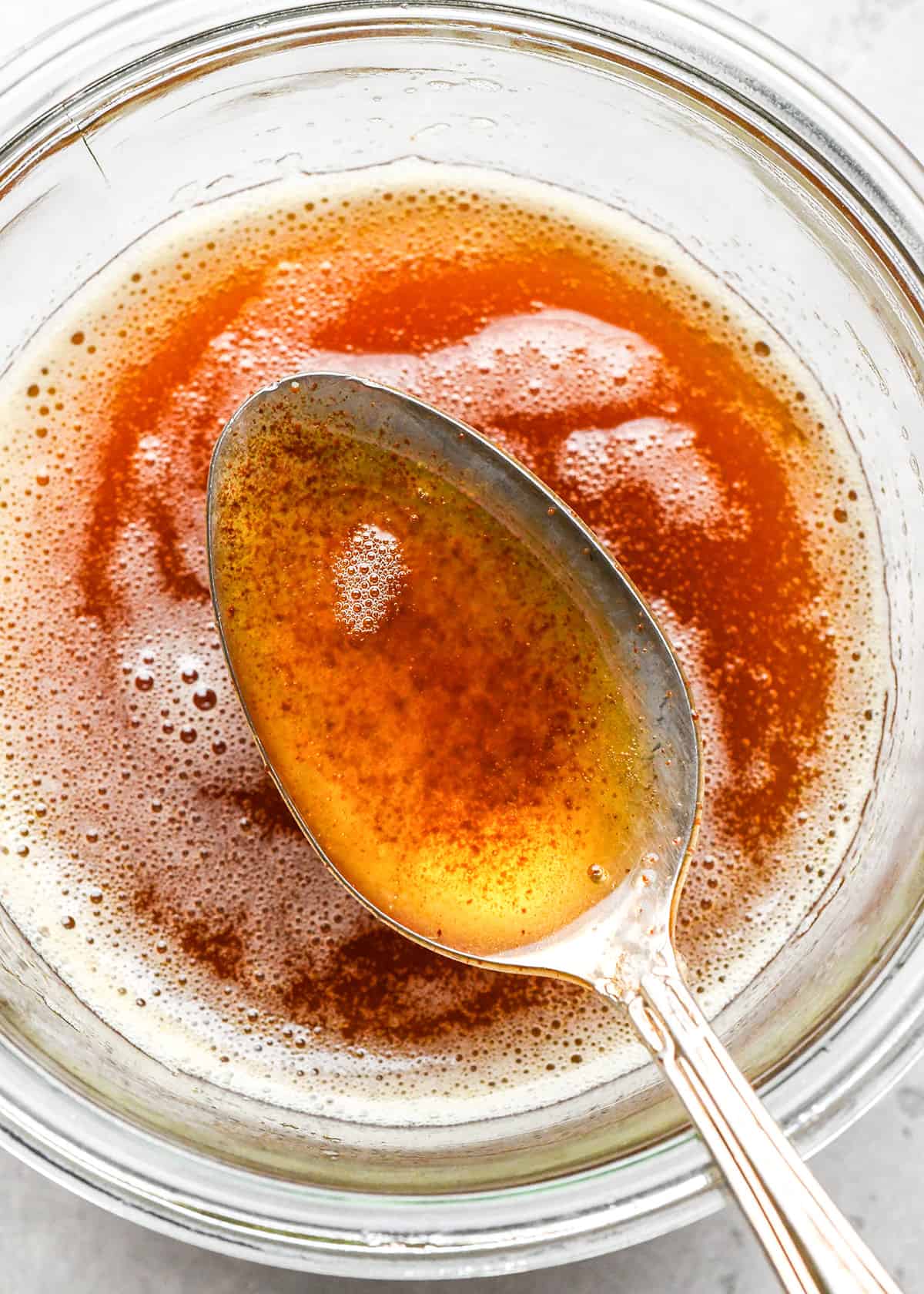 brown butter in a glass jar with a spoon