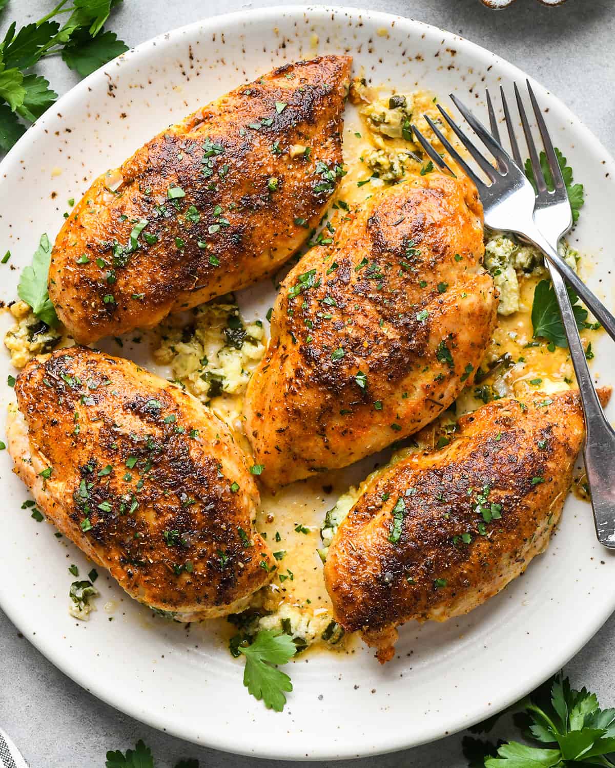 4 Spinach Stuffed Chicken Breasts on a plate with two forks