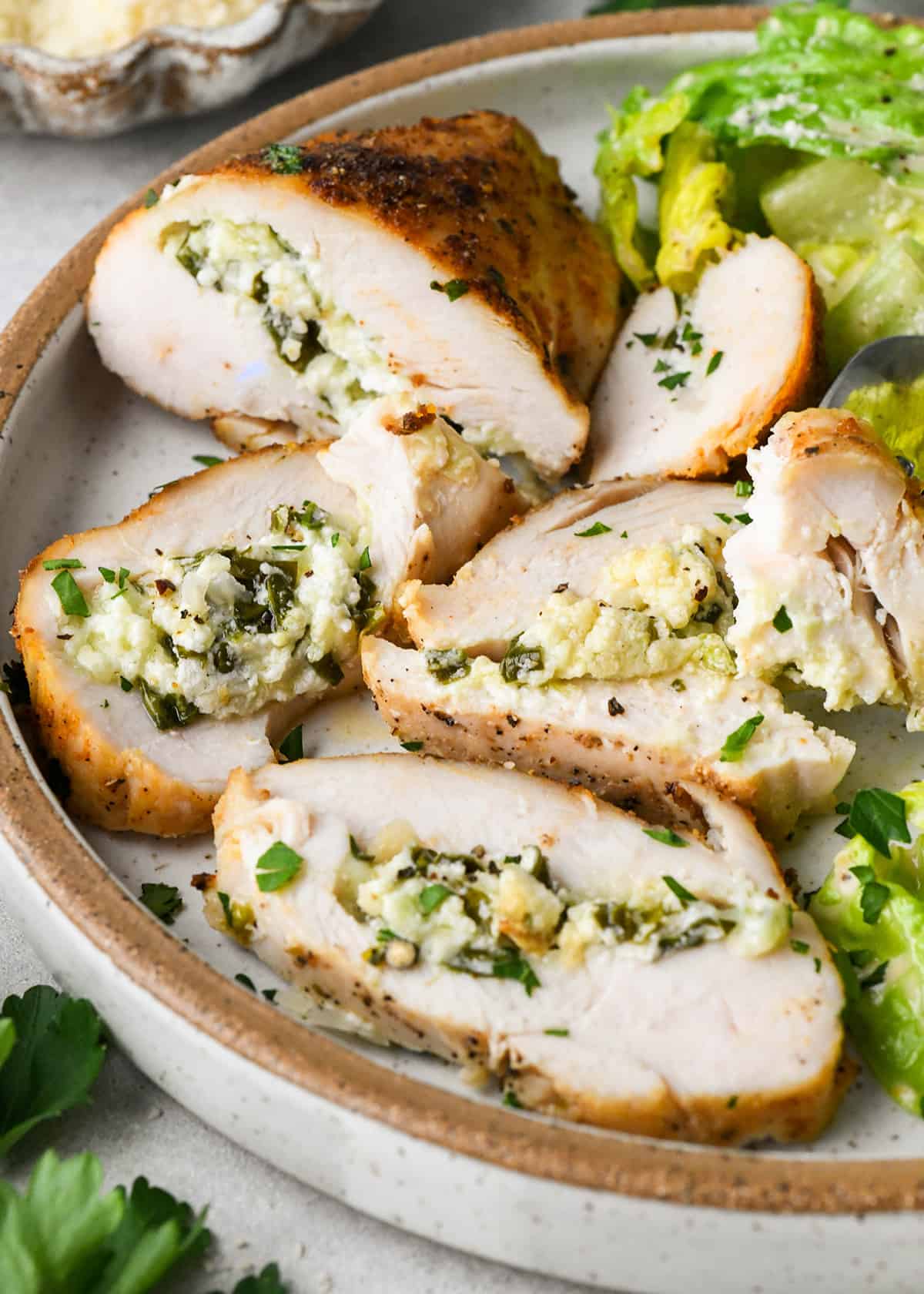 Spinach Stuffed Chicken Breast on a plate with 4 pieces cut out
