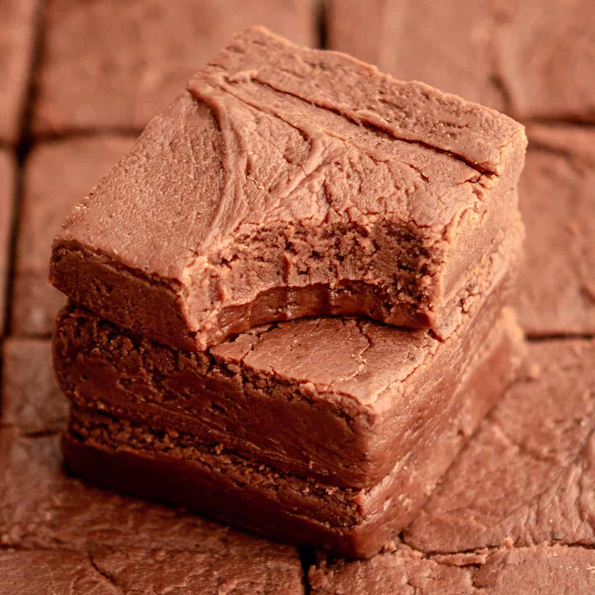 a stack of 3 pieces of Chocolate Fudge, one with a bite taken out of it