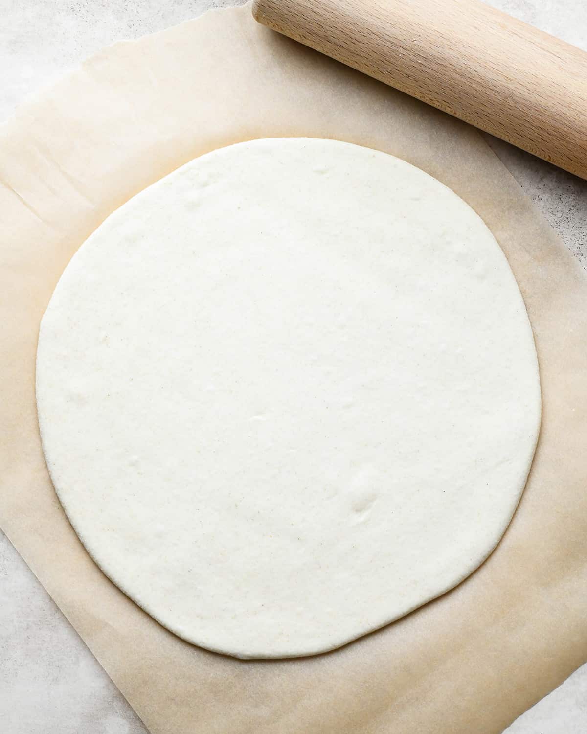How to Make Pepperoni Pizza - pizza dough rolled into a circle