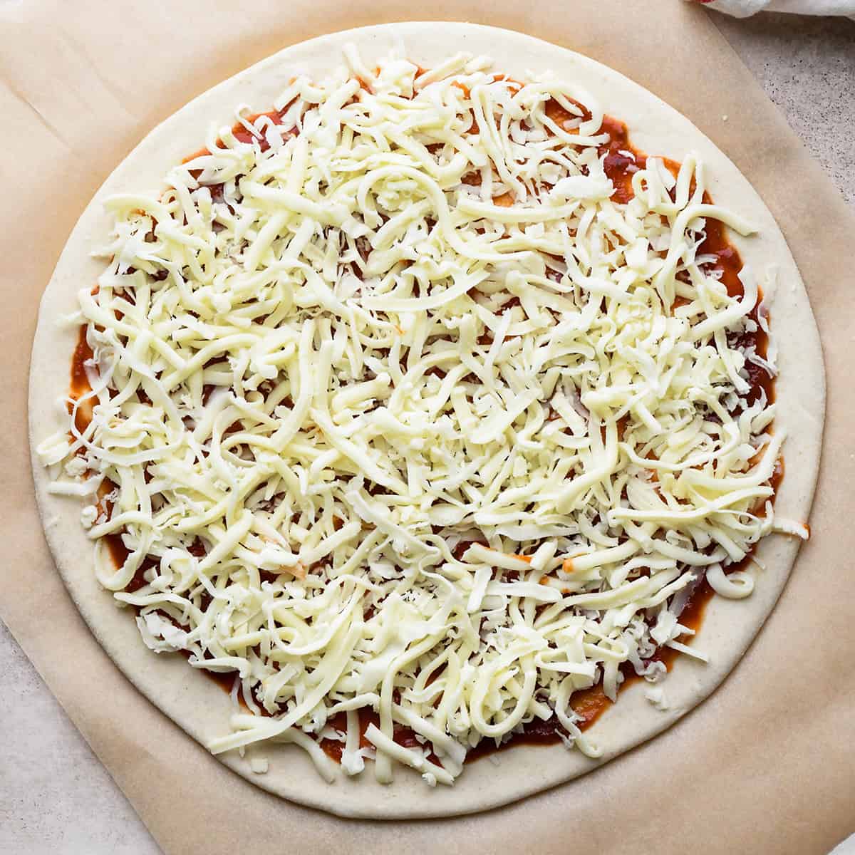 How to Make Pepperoni Pizza - putting cheese on top of sauce