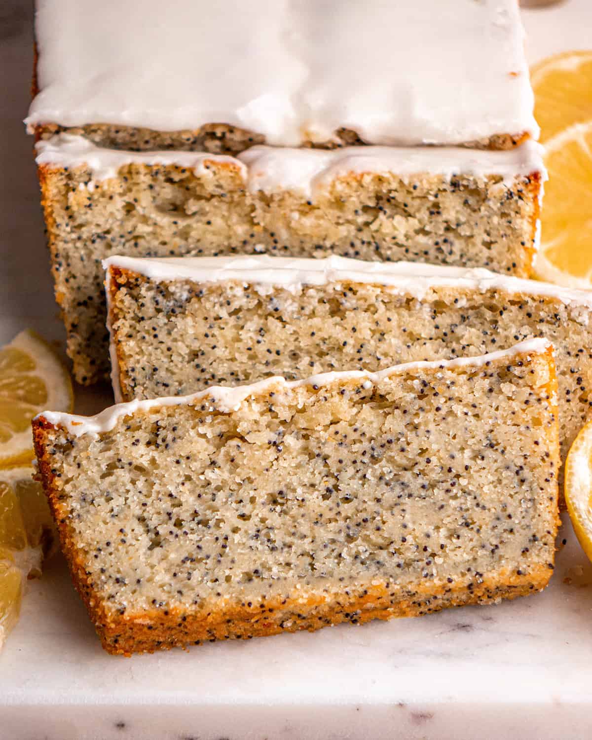 lemon poppy seed loaf with 3 slices cut out of it