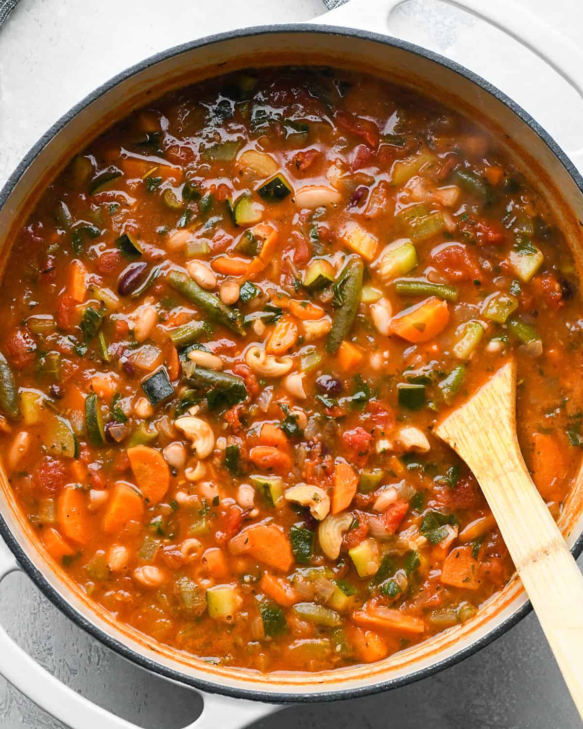 Minestrone Soup in a pot with a wooden spoon