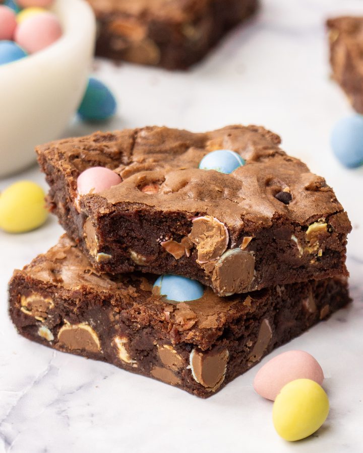 a stack of 2 mini egg brownies, the top one has a bite taken out of it
