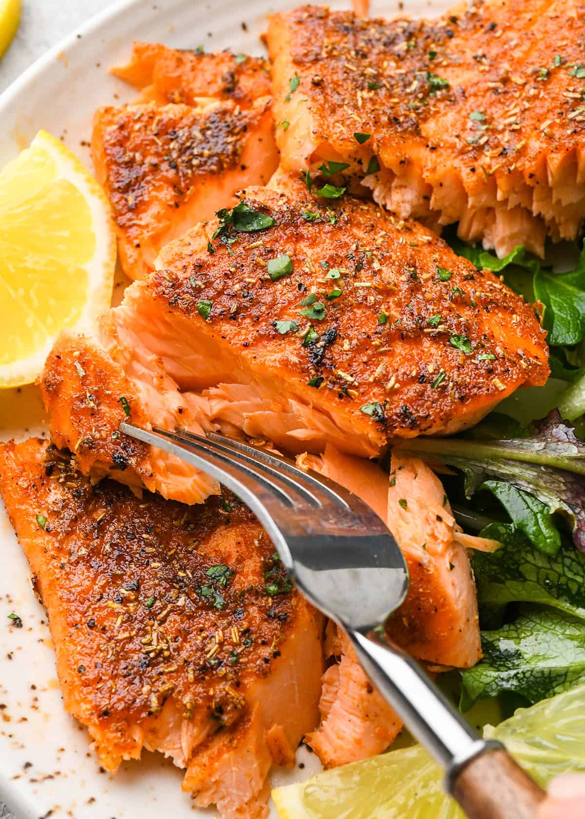 Oven Baked Salmon on a plate with a fork and salad