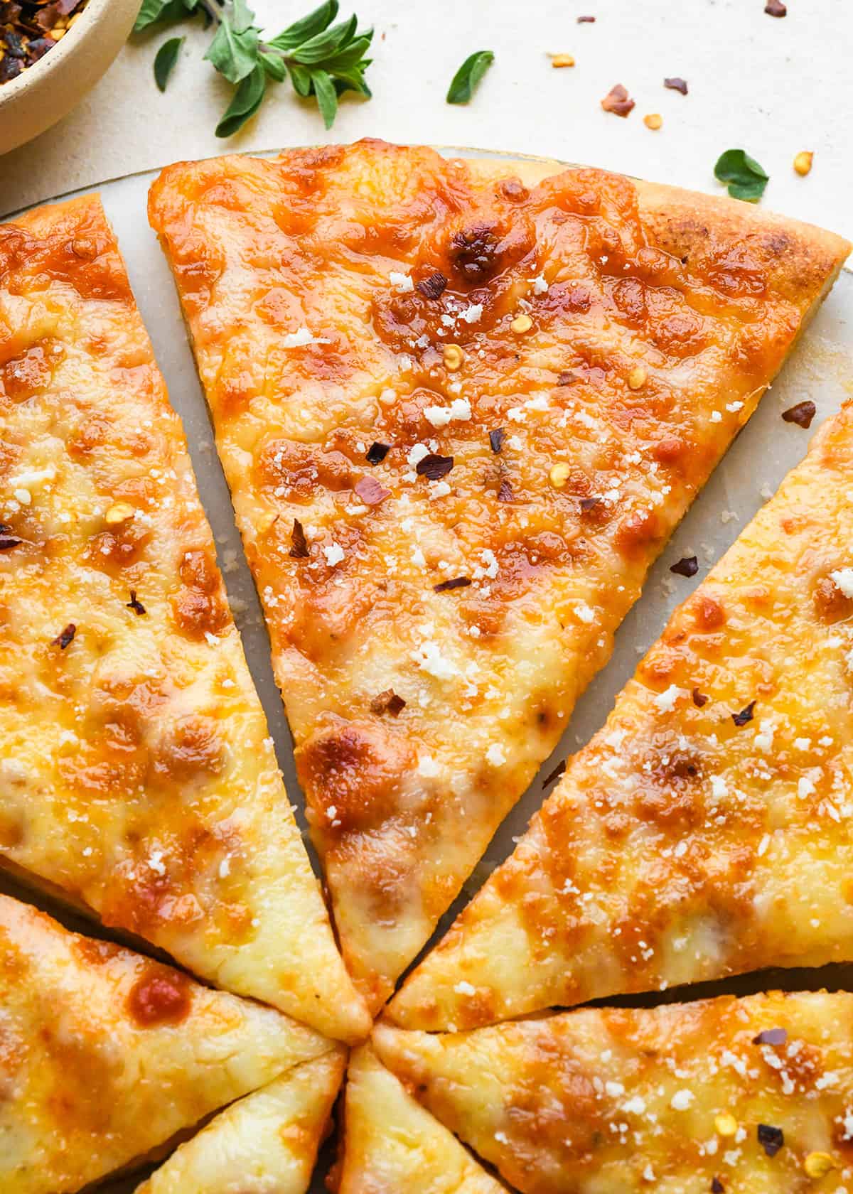 slices of Cheese Pizza sprinkled with parmesan and red pepper flakes