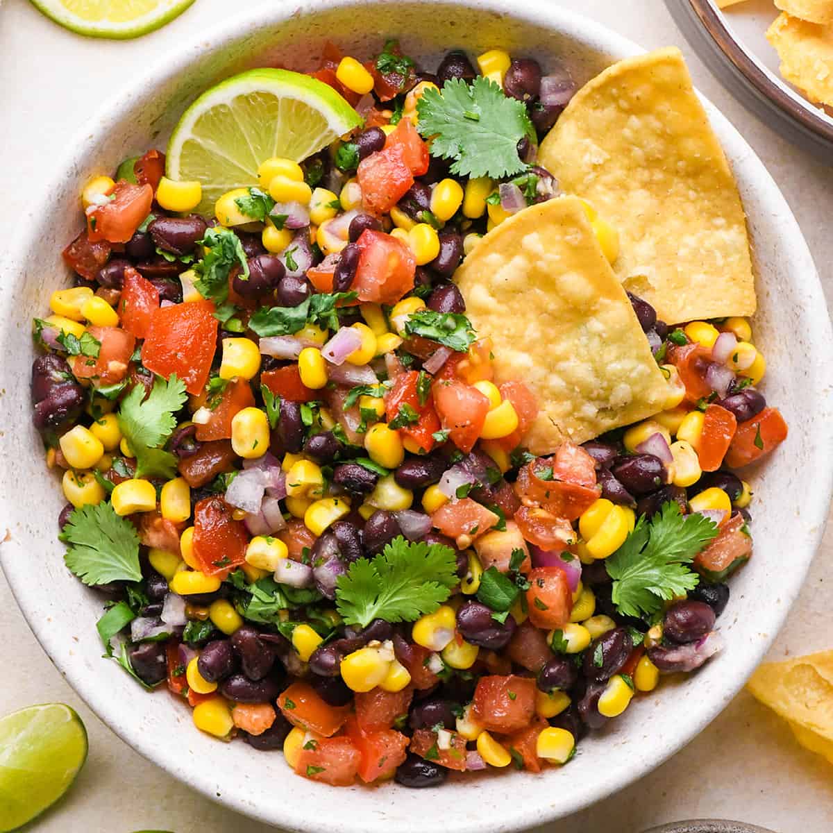 a bowl of Black Bean and Corn Salsa with two chips