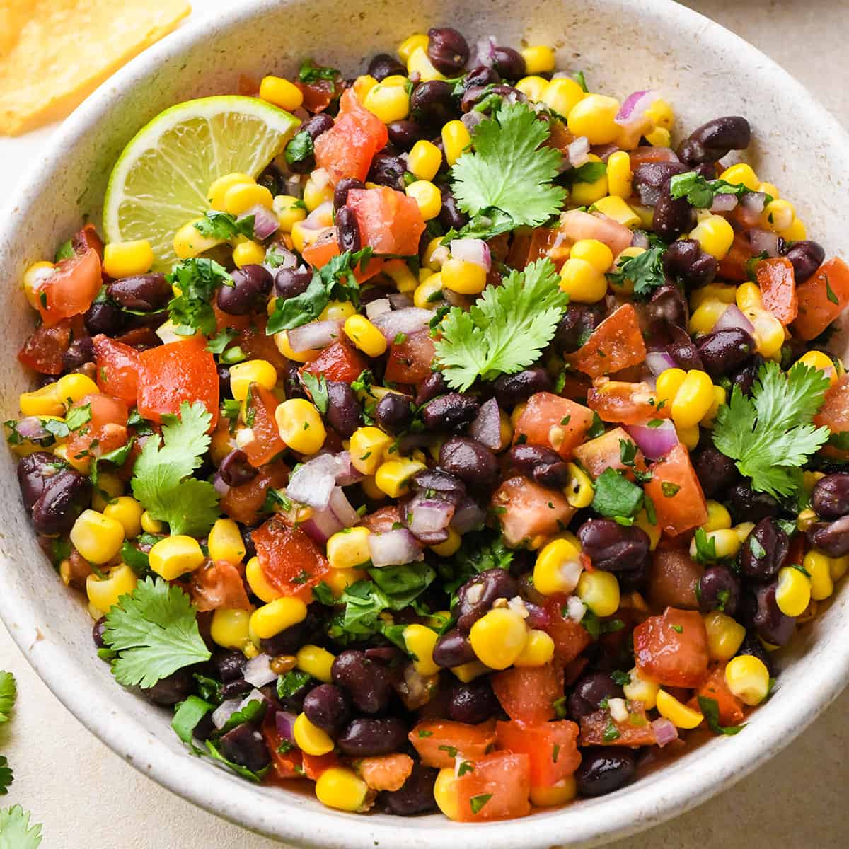 a bowl of Black Bean and Corn Salsa garnished with cilantro