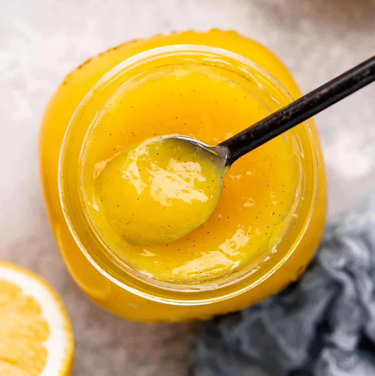 overhead view of Lemon Curd in a glass jar with a spoon