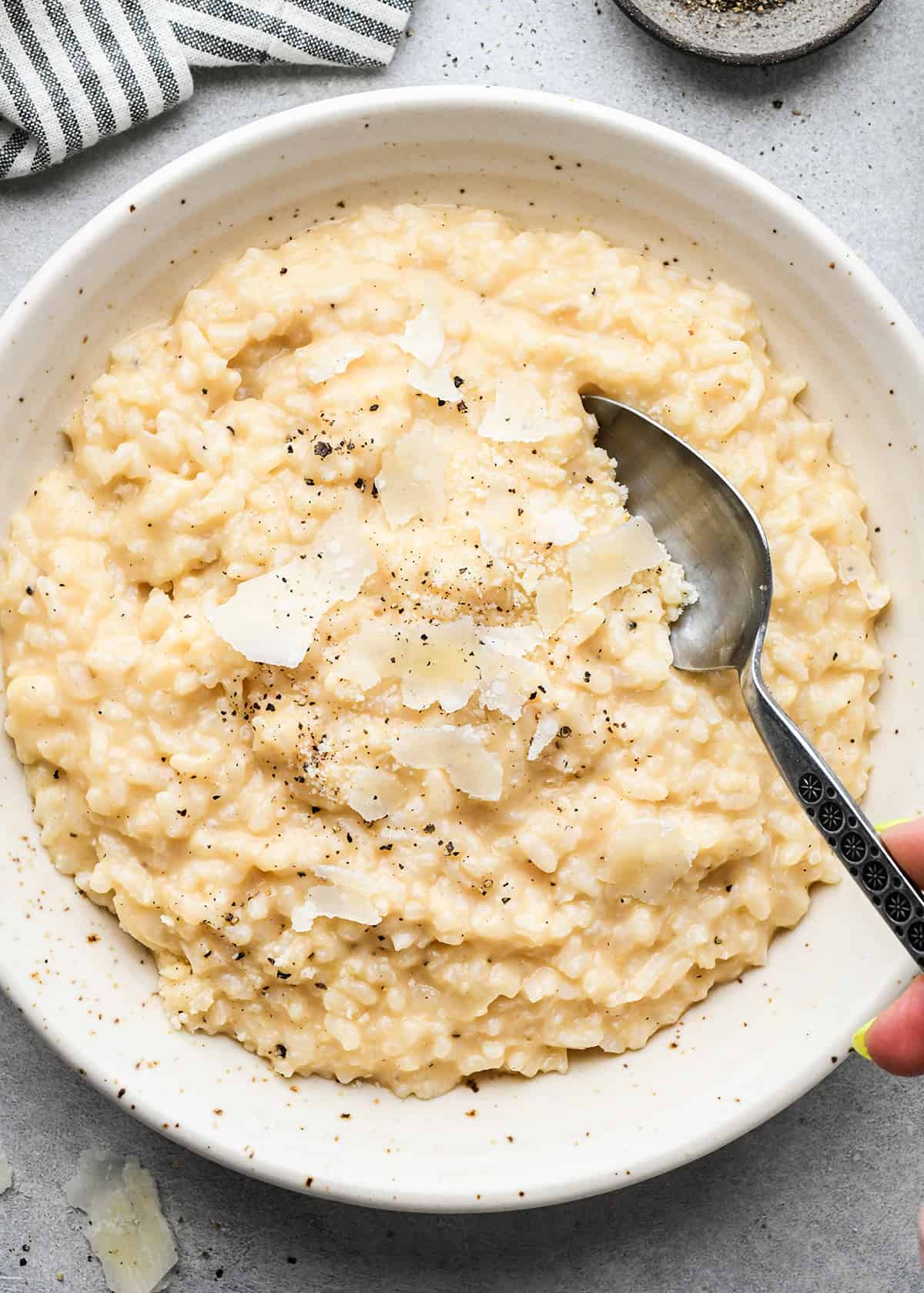 a spoon taking a scoop of risotto in a bowl
