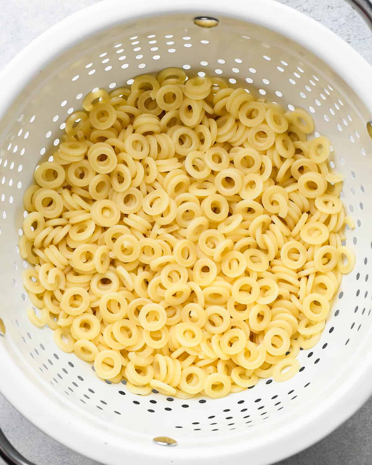 O shaped pasta in a colander draining after cooking
