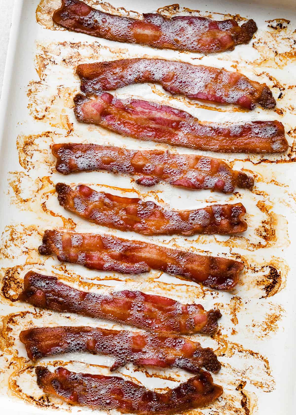How to Cook Bacon in the Oven - 9 cooked pieces of bacon on a baking sheet