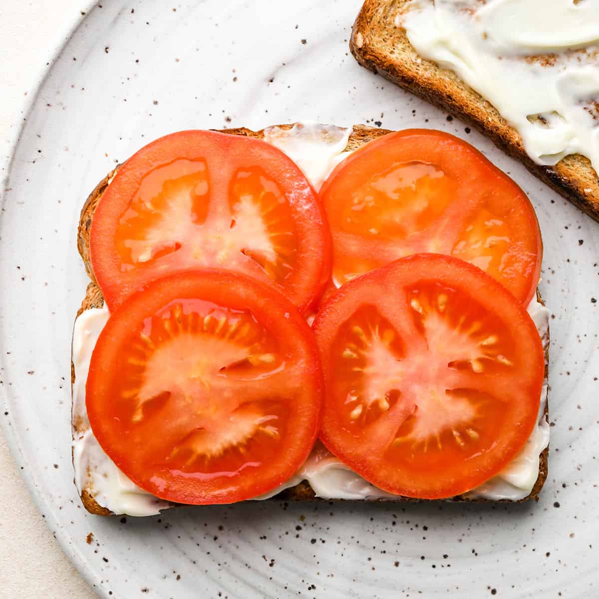 assembling a BLT sandwich - adding tomato