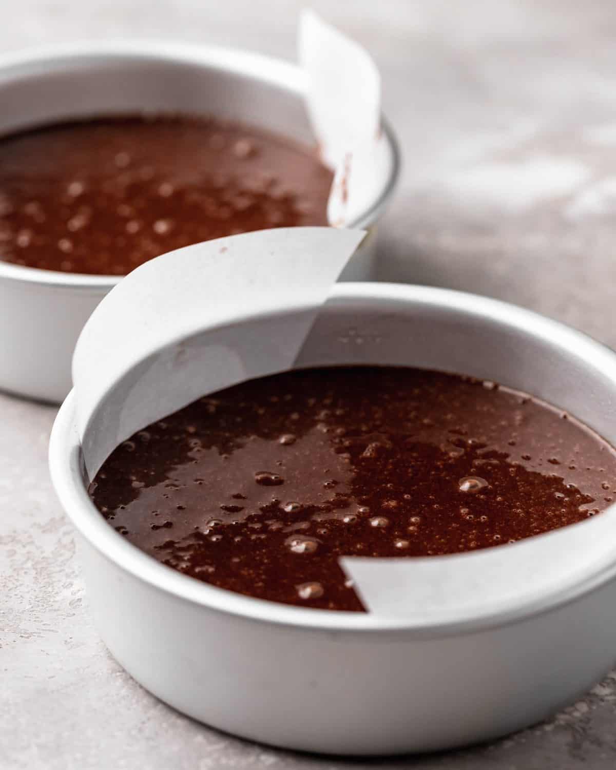 how to make chocolate cake from scratch - front photo of the cake batter in two lined round 6" metal cake pans