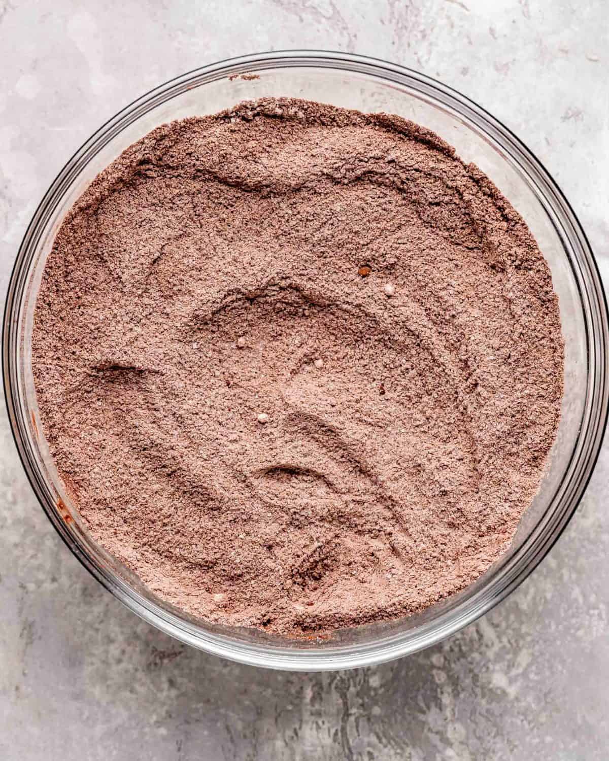 how to make chocolate cake recipe - dry ingredients in a glass bowl on a gray surface after mixing