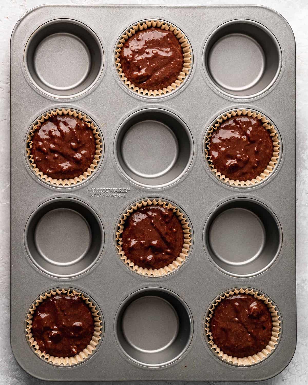 6 chocolate muffins in a muffin tin before baking