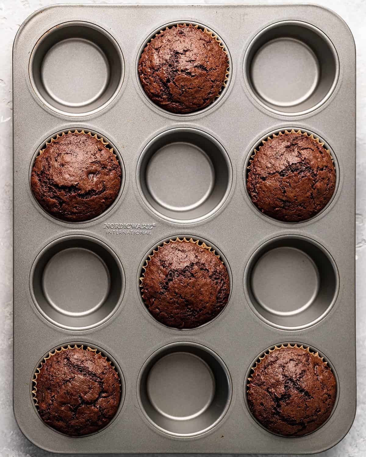 6 chocolate muffins in a muffin pan after baking