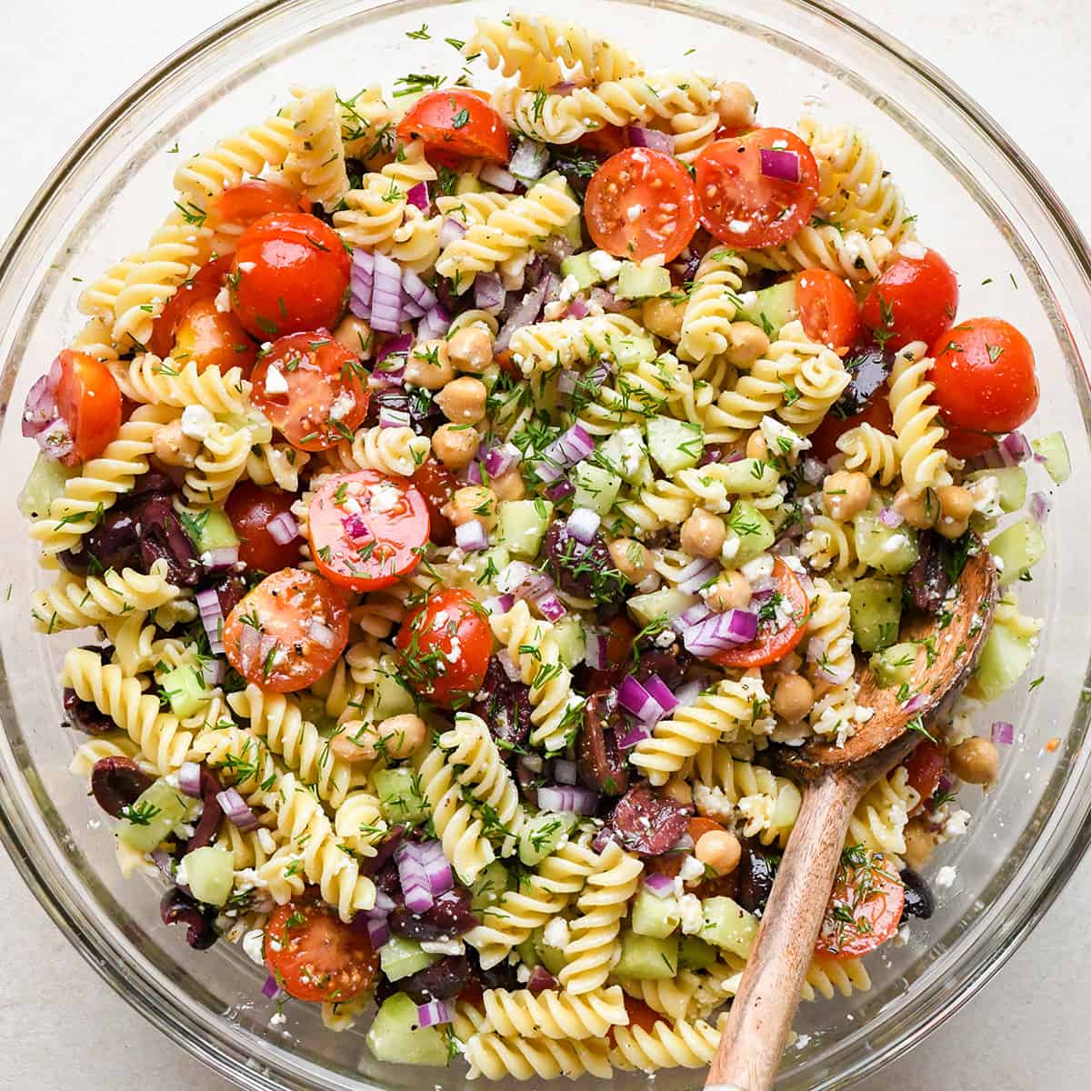 Greek Pasta Salad Recipe in a mixing bowl after mixing