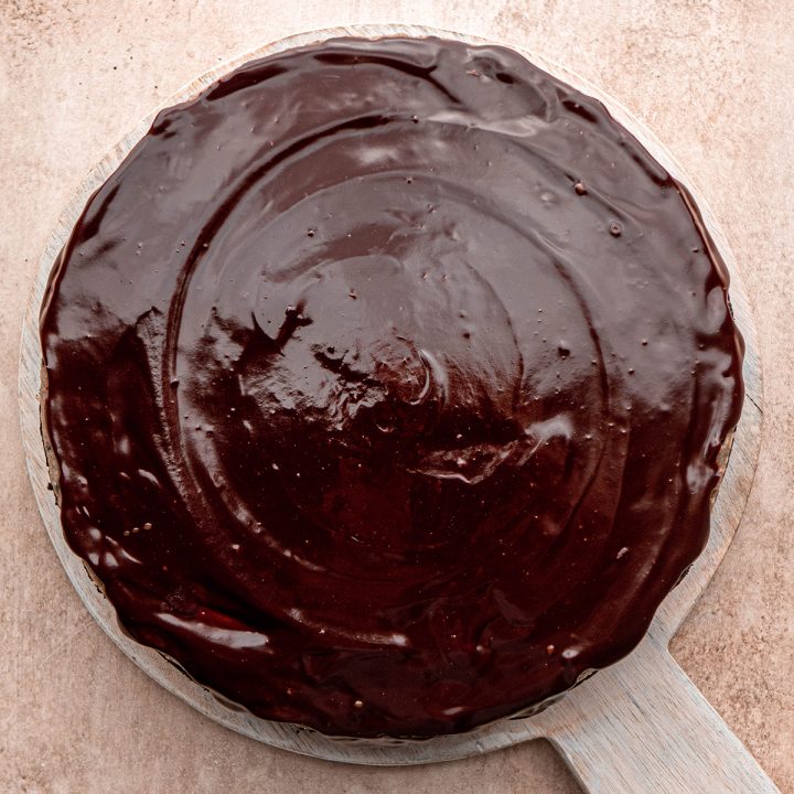 chocolate ganache spread on top of Oreo cheesecake