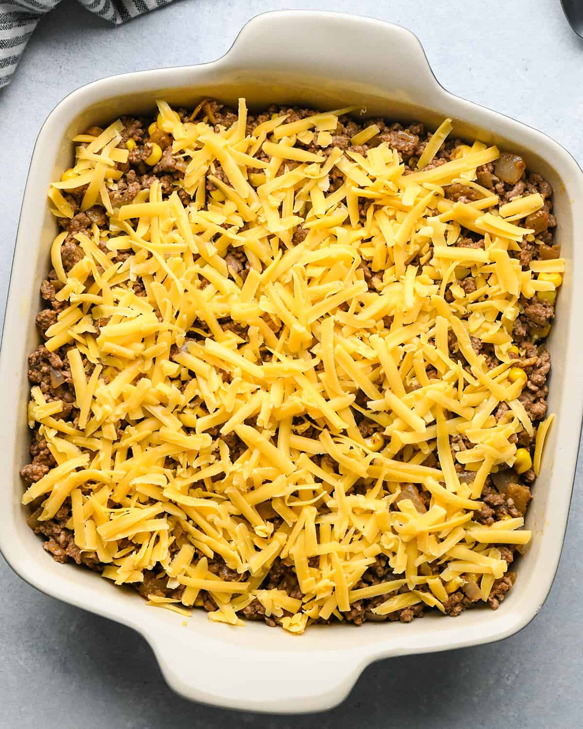 assembling Mexican Casserole, adding cheese to the top