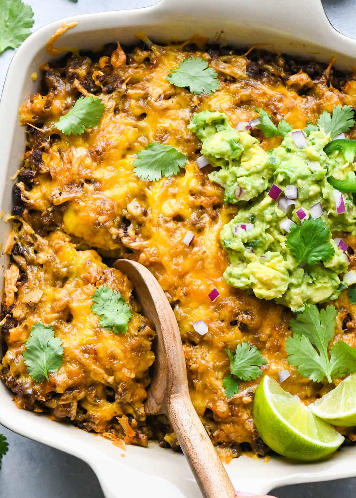 Mexican Casserole in a baking dish with a wooden spoon 