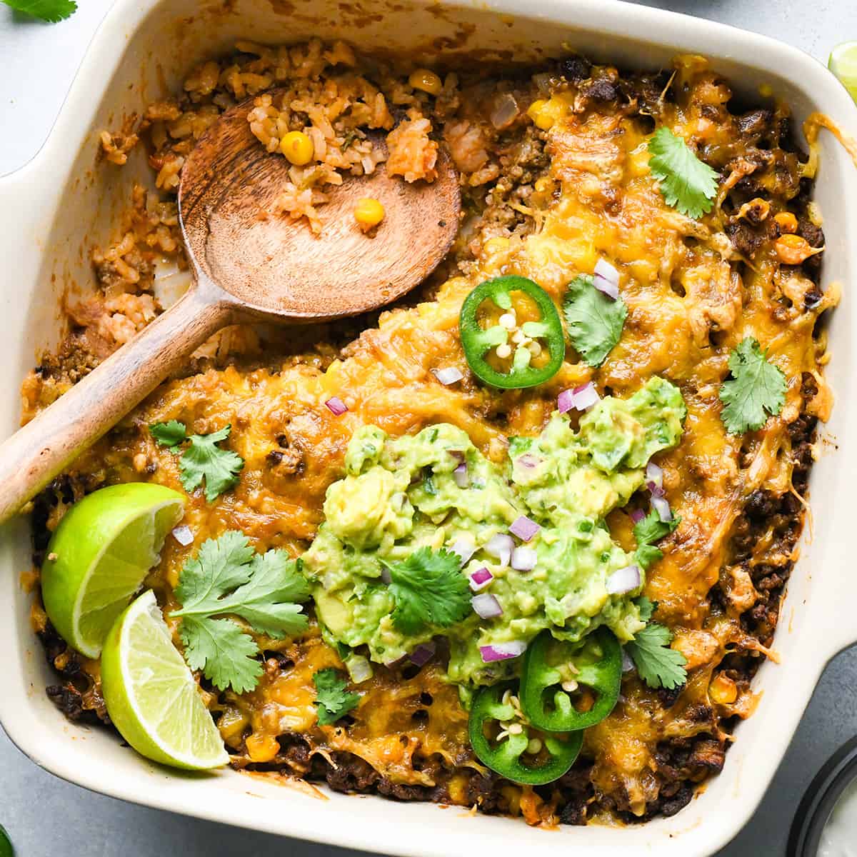 Mexican Casserole in a baking dish with a wooden spoon