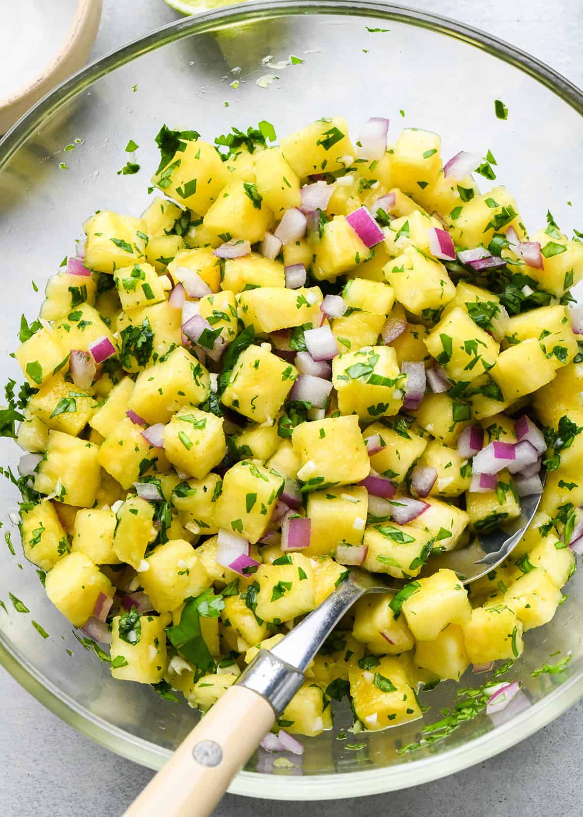 Pineapple Salsa stirred together in a glass mixing bowl