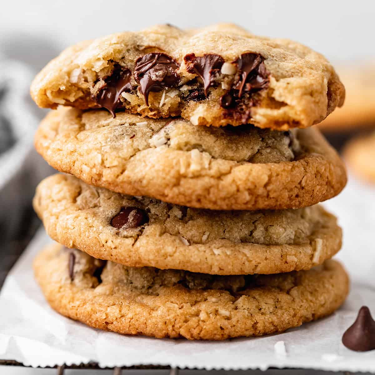 a stack of 4 Coconut Chocolate Chip Cookies, the top one has a bite taken out of it