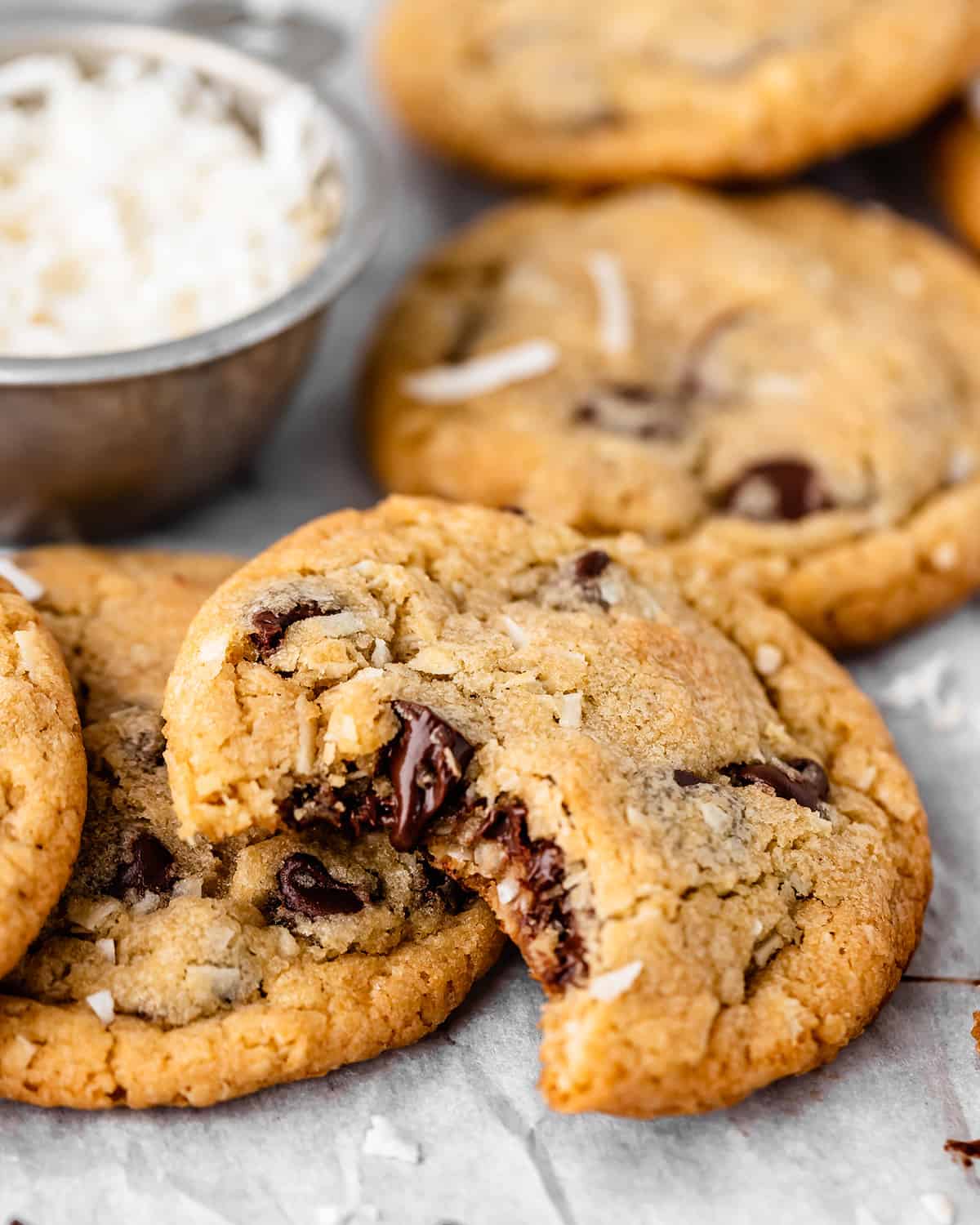 5 Coconut Chocolate Chip Cookies, one with a bite taken out of it