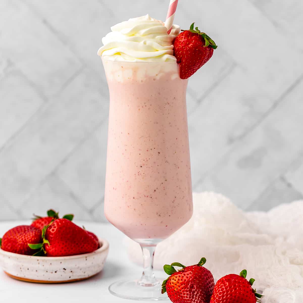Strawberry Milkshake in a glass topped with whipped cream