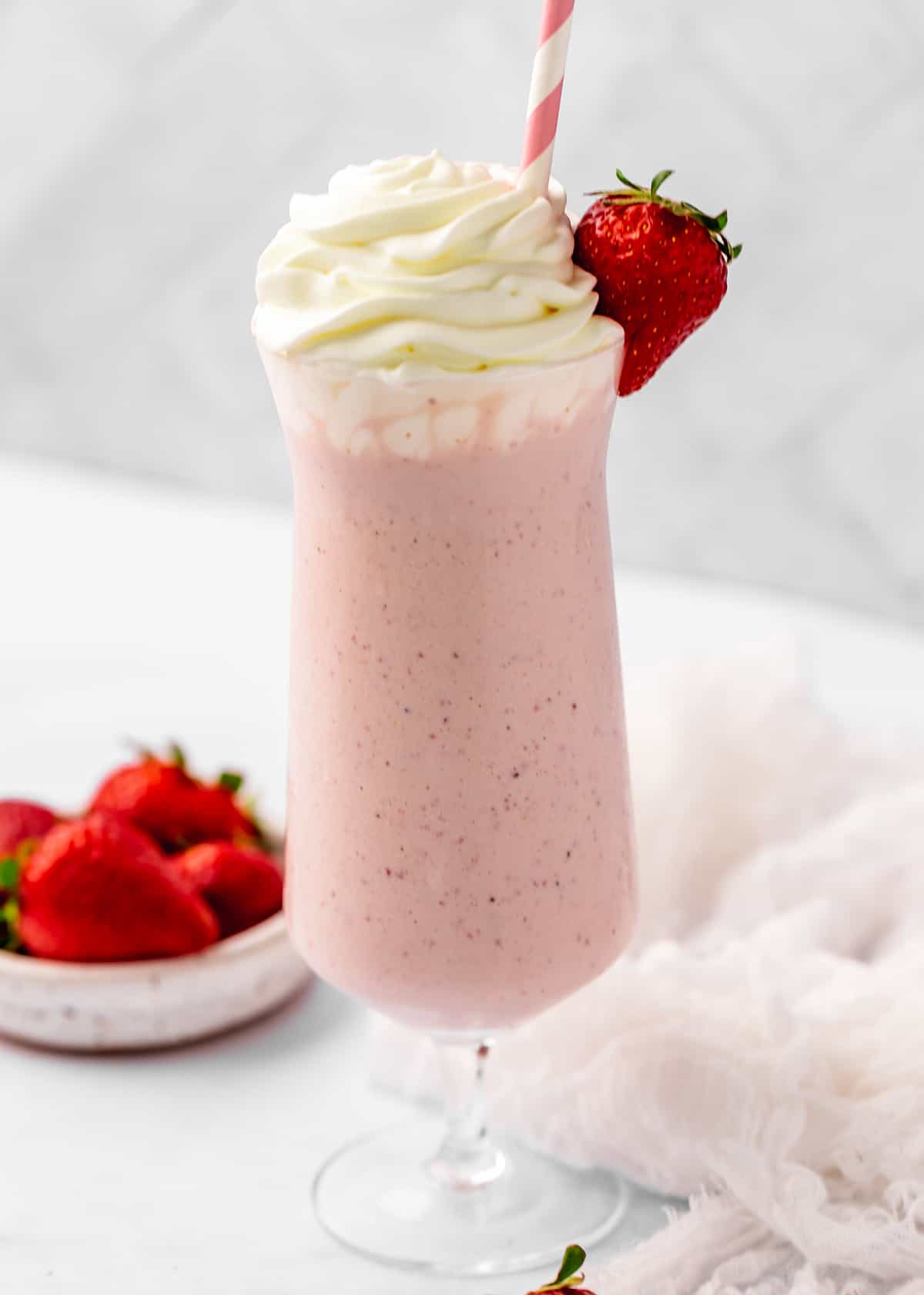 Strawberry Milkshake in a glass topped with whipped cream