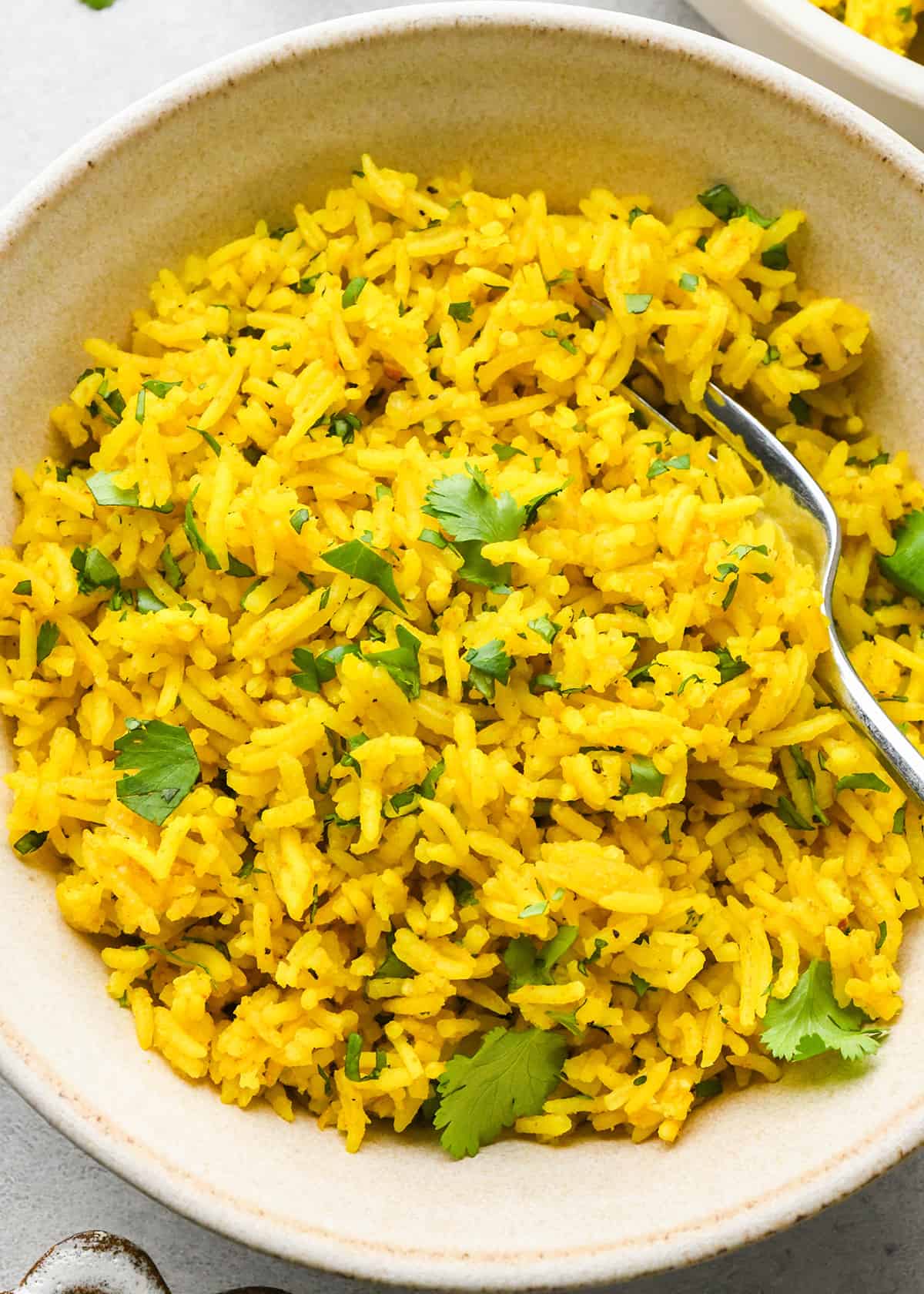yellow Rice in a bowl with a fork