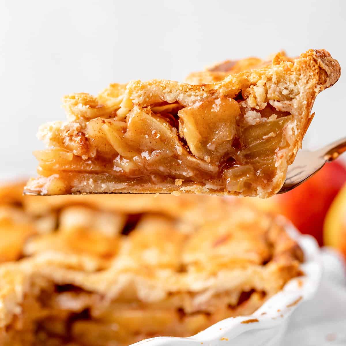 a pie server lifting a piece of apple pie out of the pie dish