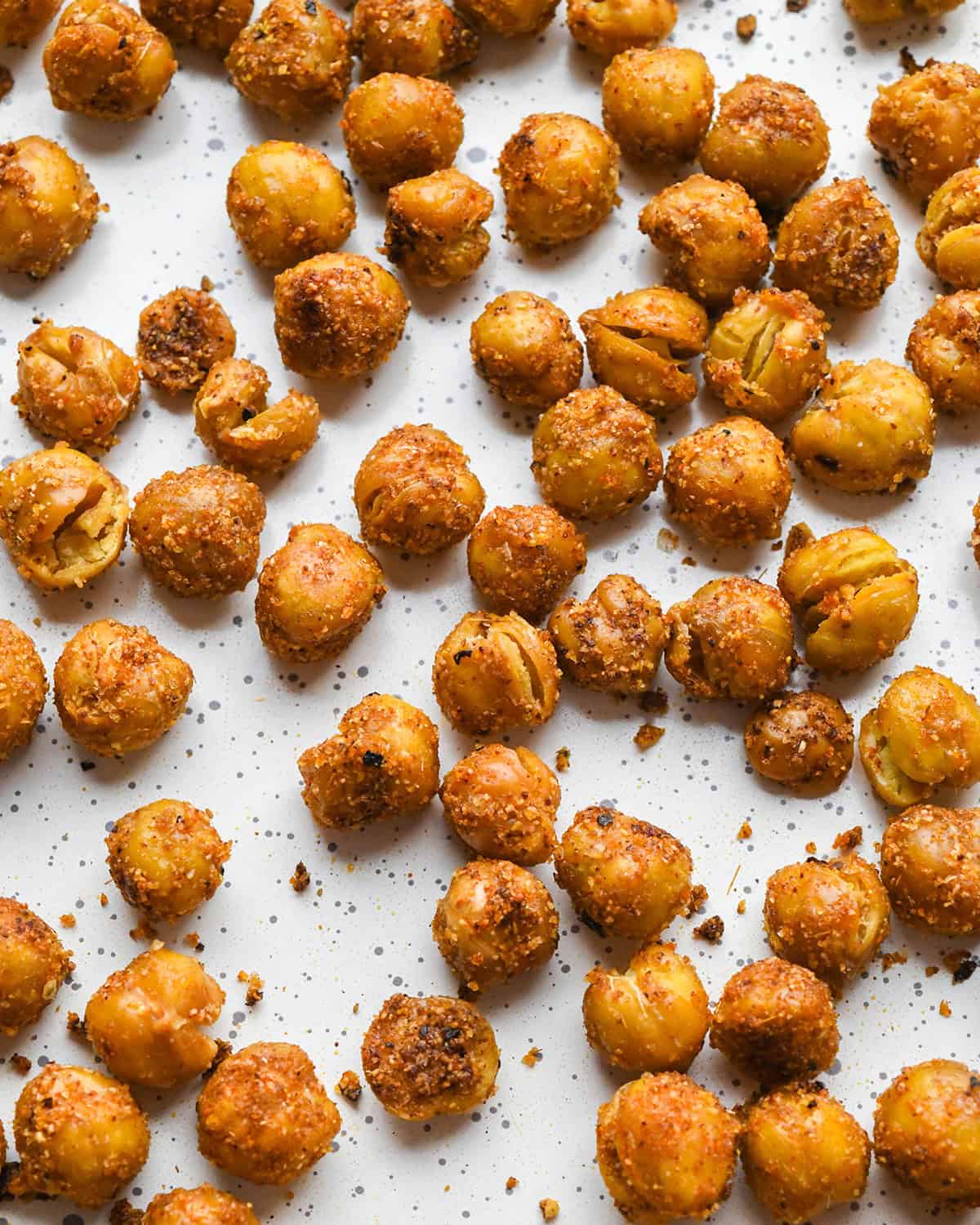 close up photo of roasted chickpeas on a white baking sheet after being roasted.