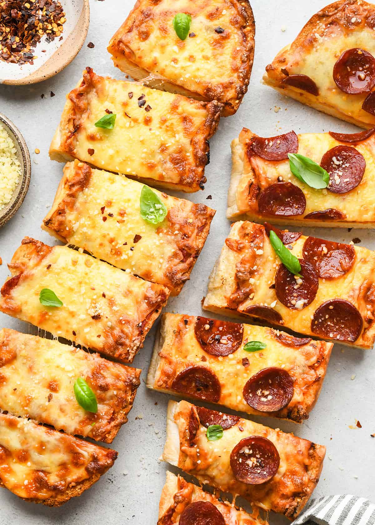 two French Bread Pizzas cut into pieces - one cheese one pepperoni