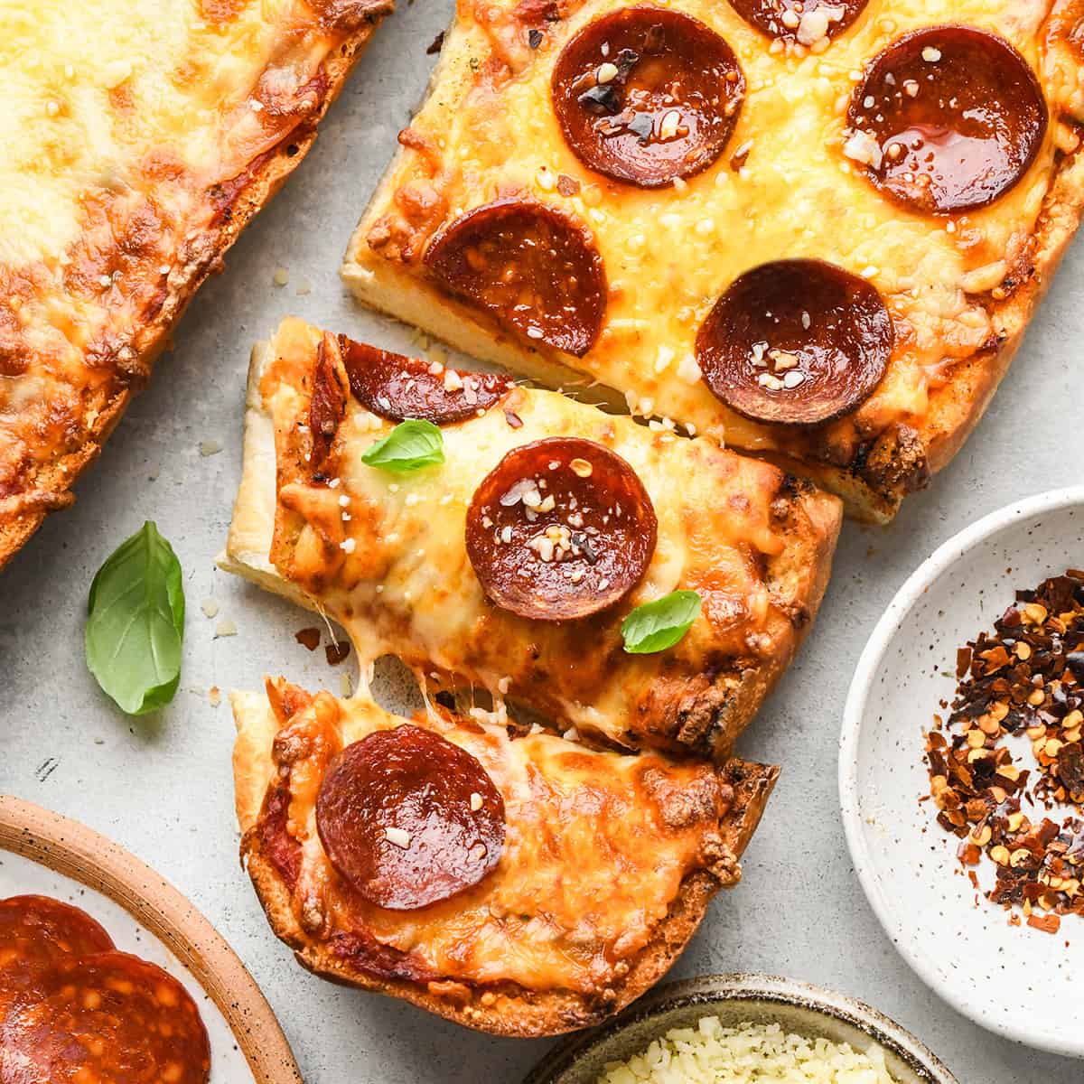 French Bread Pizza with pepperoni & 2 pieces cut out of it