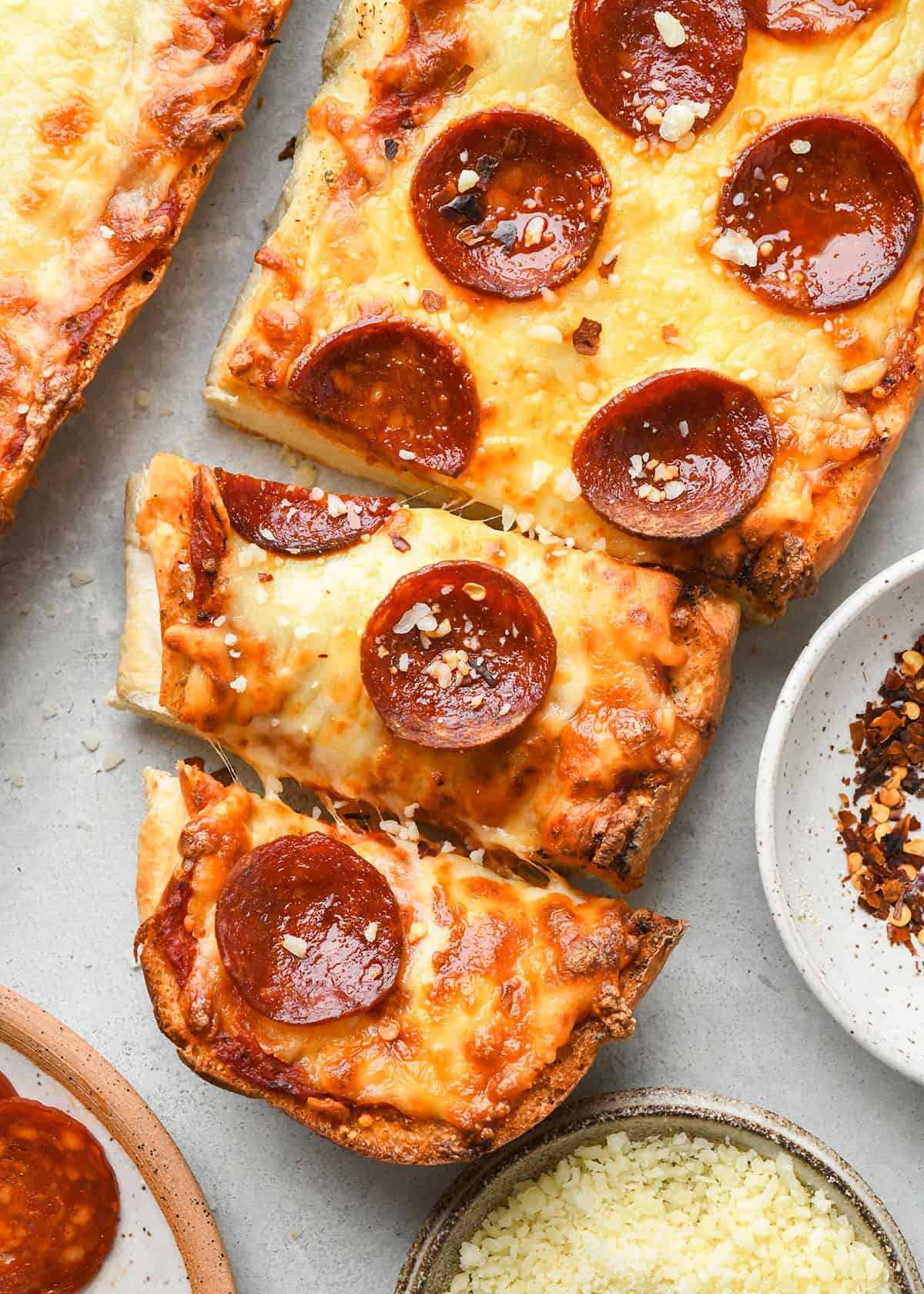 French Bread Pizza with pepperoni and two pieces cut out of it