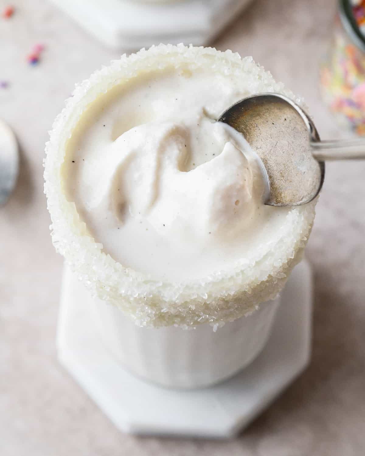 a spoon scooping Vanilla Milkshake out of a glass