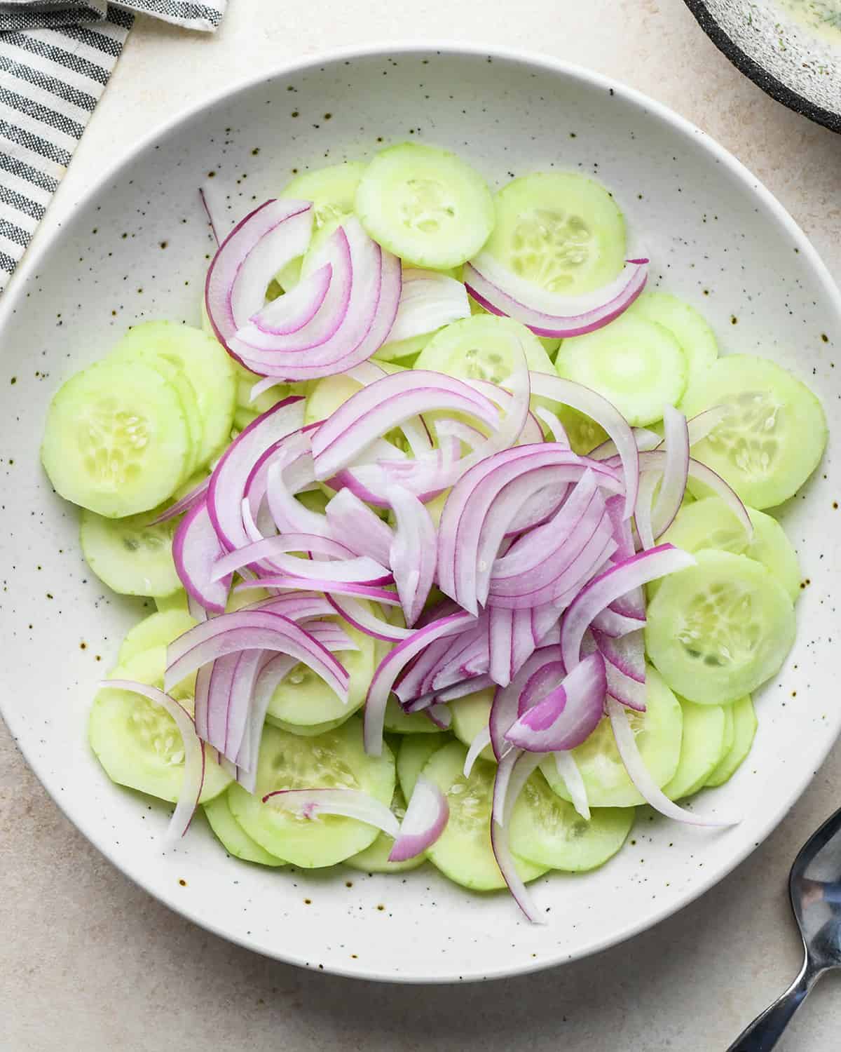 How to make Cucumber Salad  - cucumbers and onions in a bowl