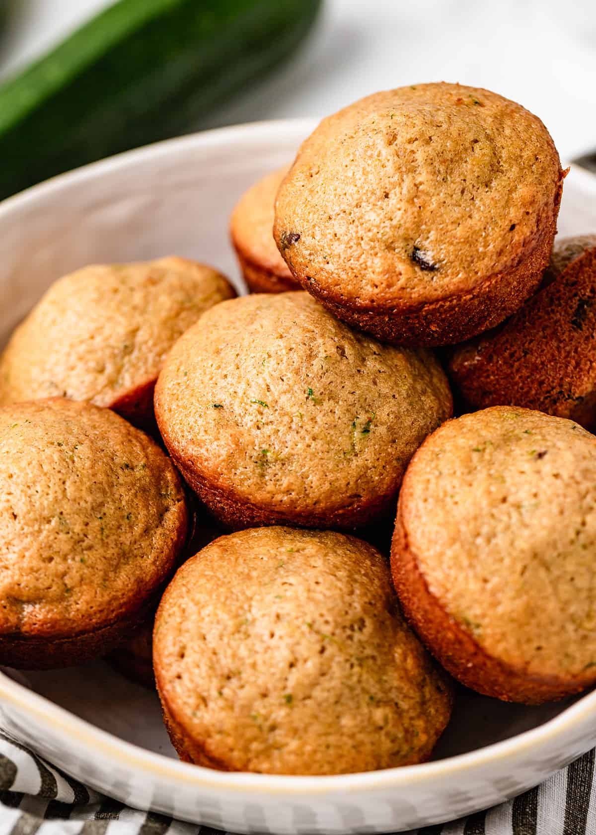 8 Zucchini Chocolate Chip Muffins  stacked on a plate