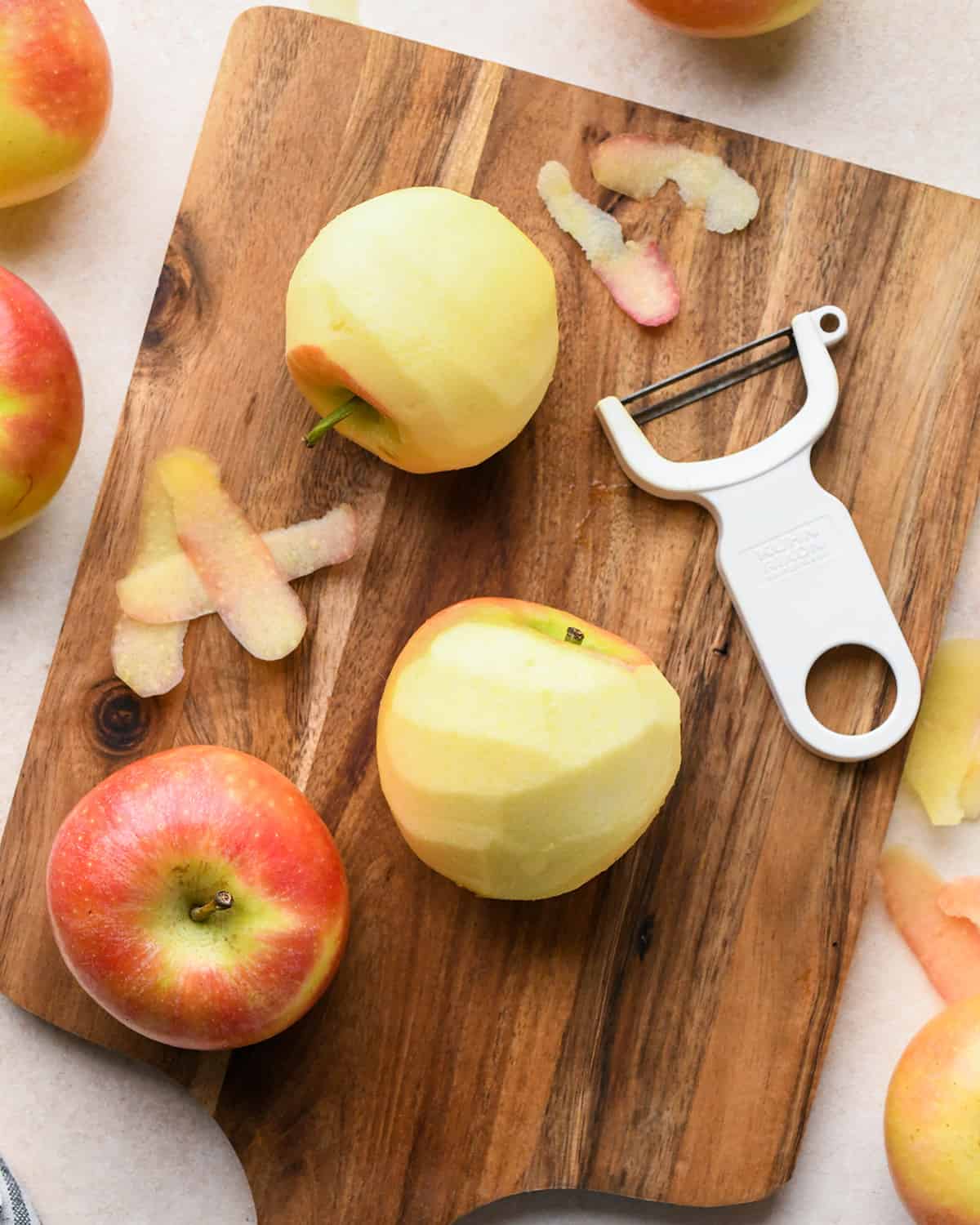 apples being peeled on a cutting board