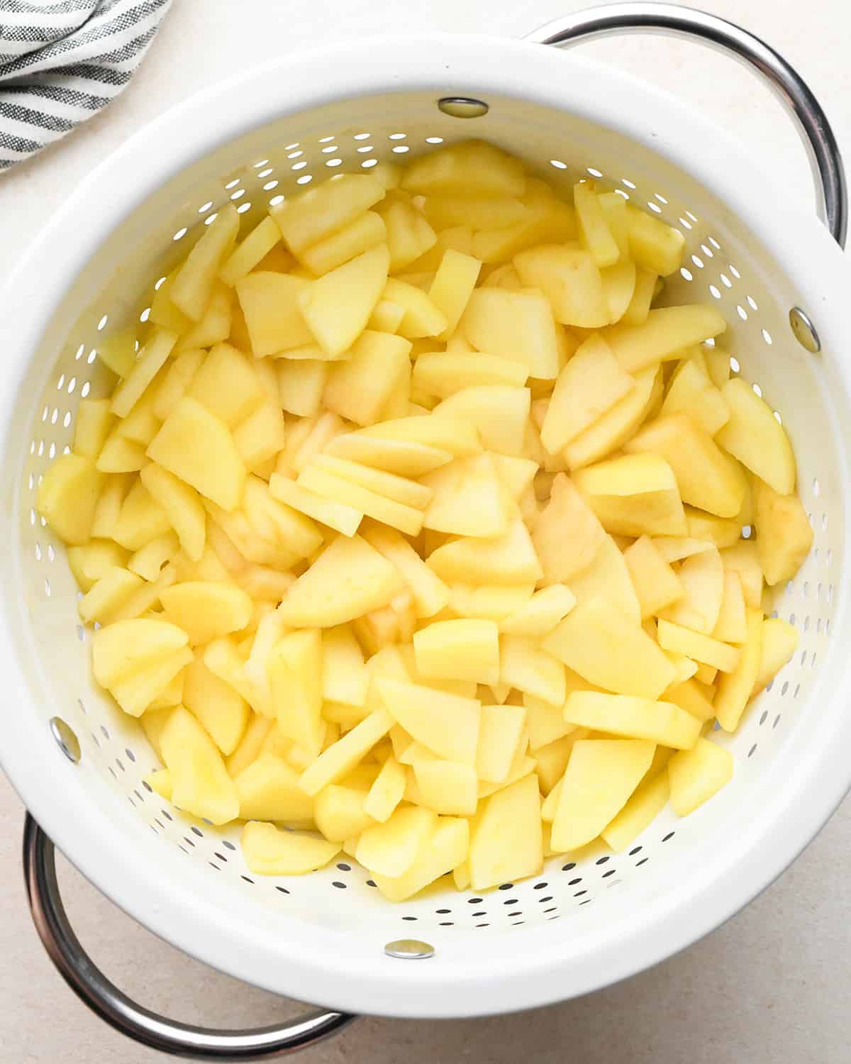 cooked, peeled and sliced apples draining in a colander