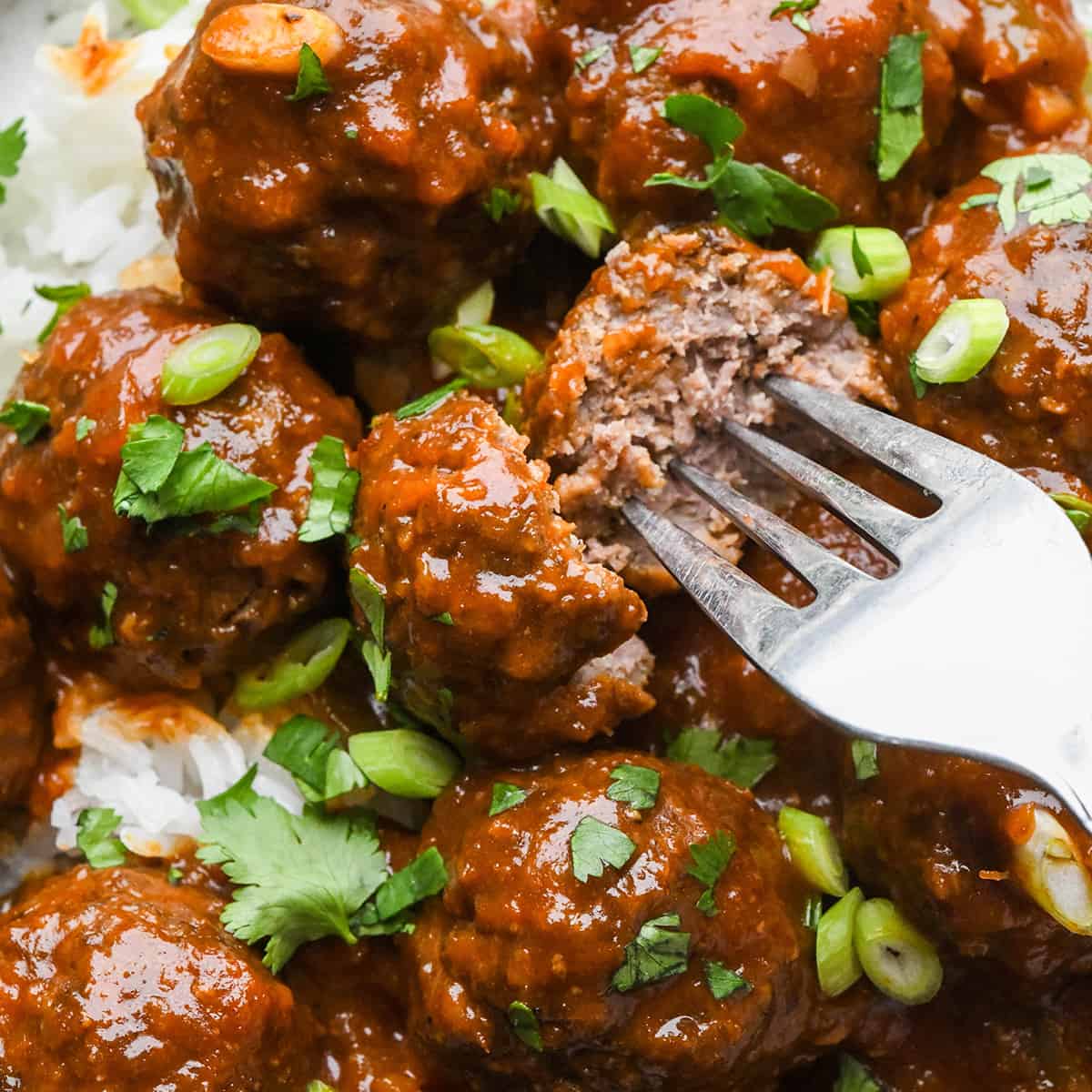 up close photo of BBQ Meatballs, one cut in half with a fork