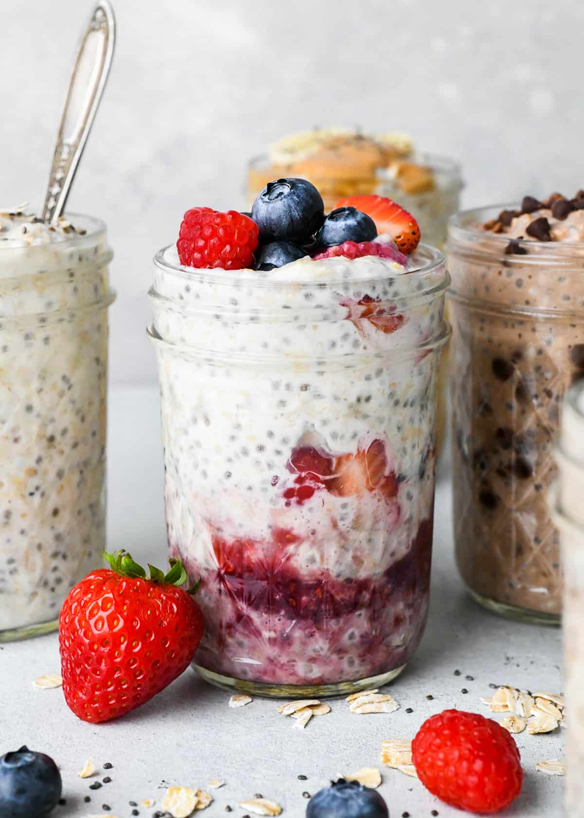 4 glass jars with different flavors of overnight oatmeal in each one